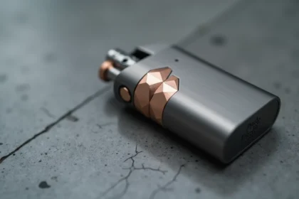 Briquet tendance 2026 en titane brossé avec incrustations or rose sur surface en béton poli