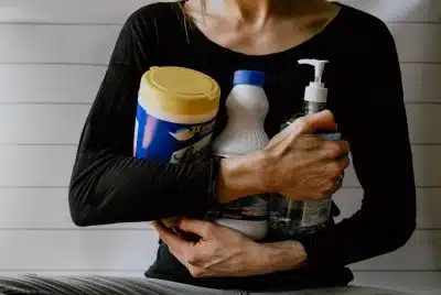 une femme avec des produits d'entretien dans les bras