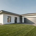Maison en L moderne avec garage intégré et façade blanche, vue extérieure grand angle