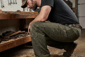 Homme portant un pantalon de travail en toile renforcée dans un atelier de bricolage