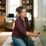 Femme peignant un mur dans un salon cosy