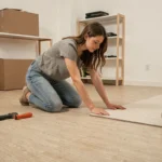 Jeune femme posant du lino pas cher dans un appartement lors d'une première rénovation