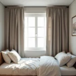 Petite chambre avec rideau occultant à motif géométrique en beige et gris pour agrandir visuellement l'espace