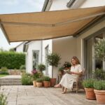 Store banne beige déployé sur une terrasse en bois d'une maison moderne, femme qui lit sous l'ombre protectrice en été