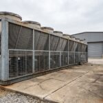 Système de refroidissement à sec industriel avec échangeurs à ailettes et ventilateurs installé sur dalle béton en extérieur d'usine