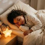 Petite fille endormie dans sa chambre avec une veilleuse apaisante sur la table de nuit